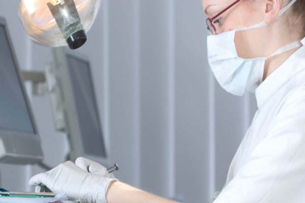 Two male dental students working on a mouth model