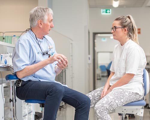 Male academic staff member talking to a female dental student