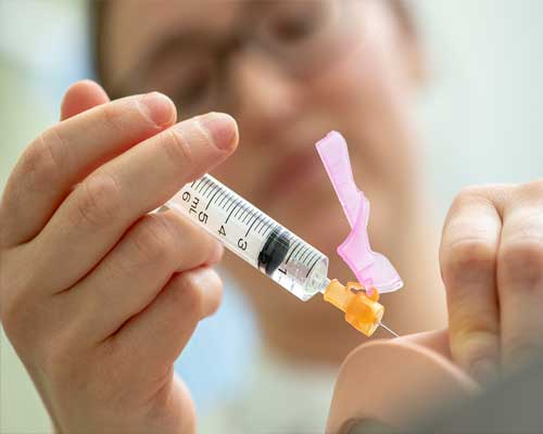 Female student nurse injecting into a dummy