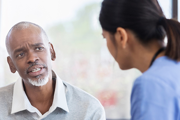 Concerned senior adult asks question during medical appointment