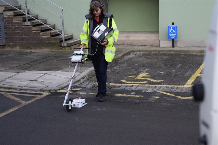 Researcher using ground penetrating radar device