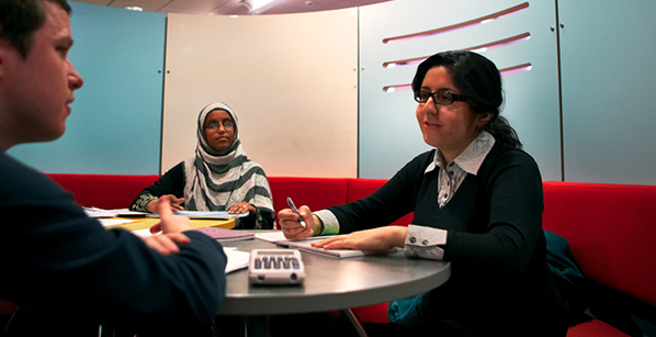 3 adults having a discussion sitting around a table