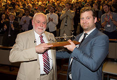 Male chemist handing another male chemist an award