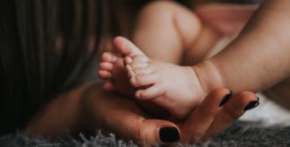A mother holding her baby's feet.