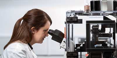 Woman looking through a microscope