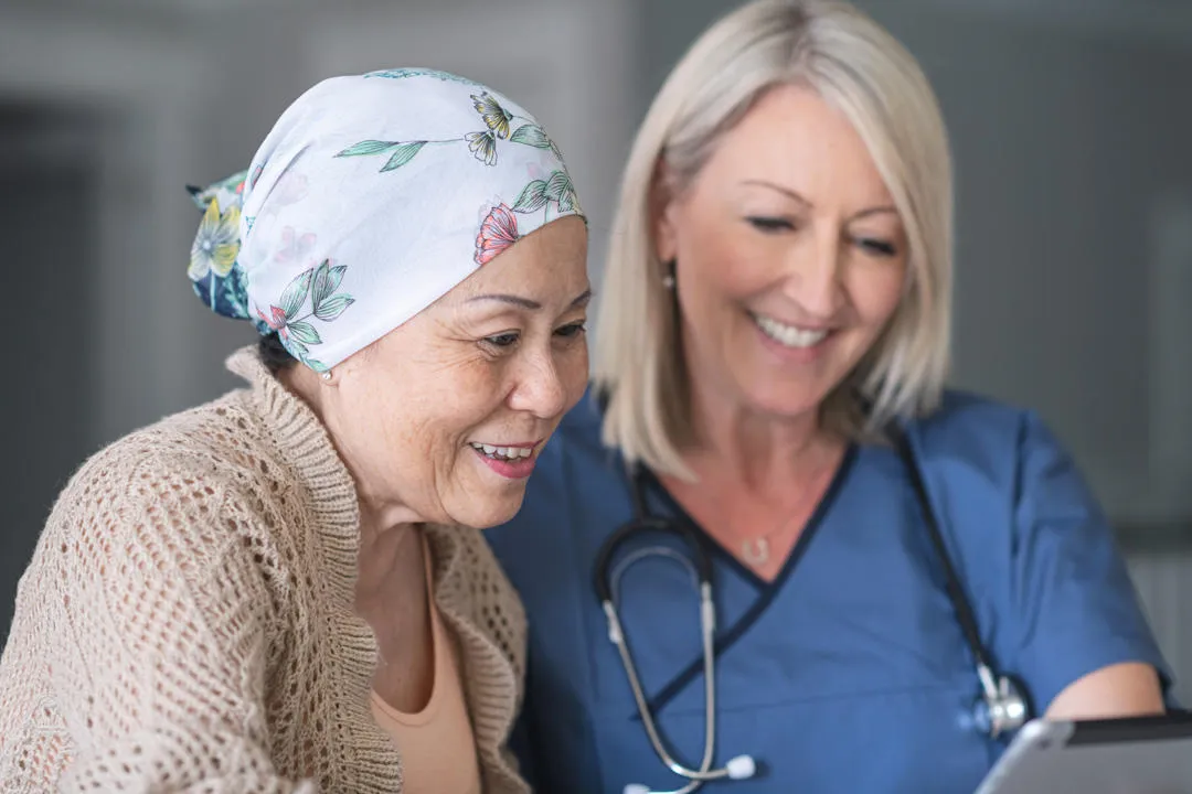 Woman wearing headscarf looks at chart with doctor wearing stethoscope